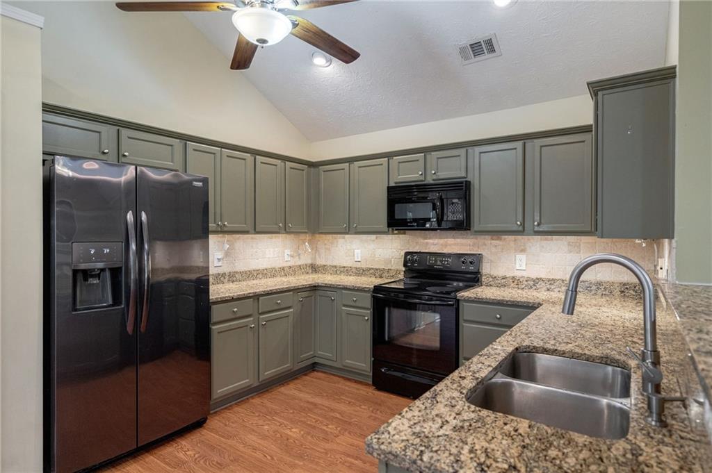 245 Memory Lane Winder, GA 30680 - Photo 14 of 62 a kitchen with stainless steel appliances granite countertop a sink stove and refrigerator