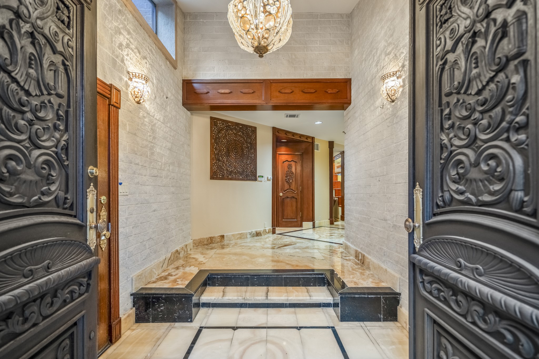 6535 Buffalo Speedway Houston, TX 77005 - Photo 8 of 40 Upon entry, step through dramatic carved double front doors into a stunning grand foyer with hand-laid onyx floors and stone accents. An elegant introduction to the home’s timeless style.