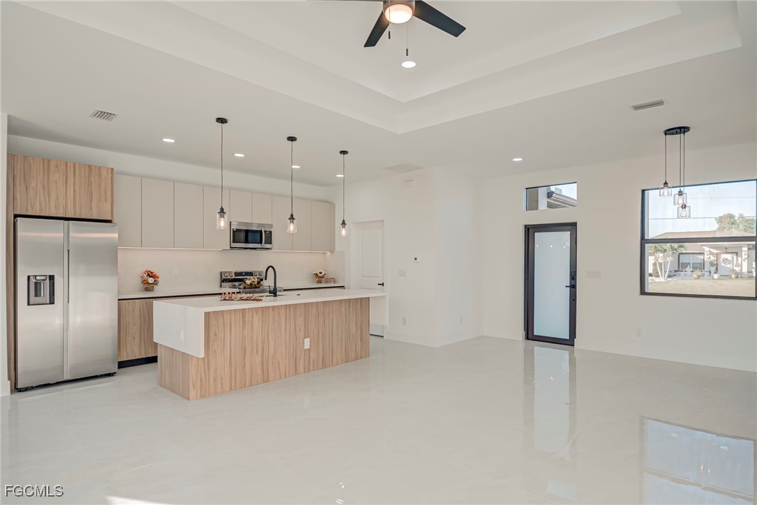 3601 28th Street Southwest Lehigh Acres, FL 33976 - Photo 13 of 35 a large white kitchen with white cabinets and stainless steel appliances