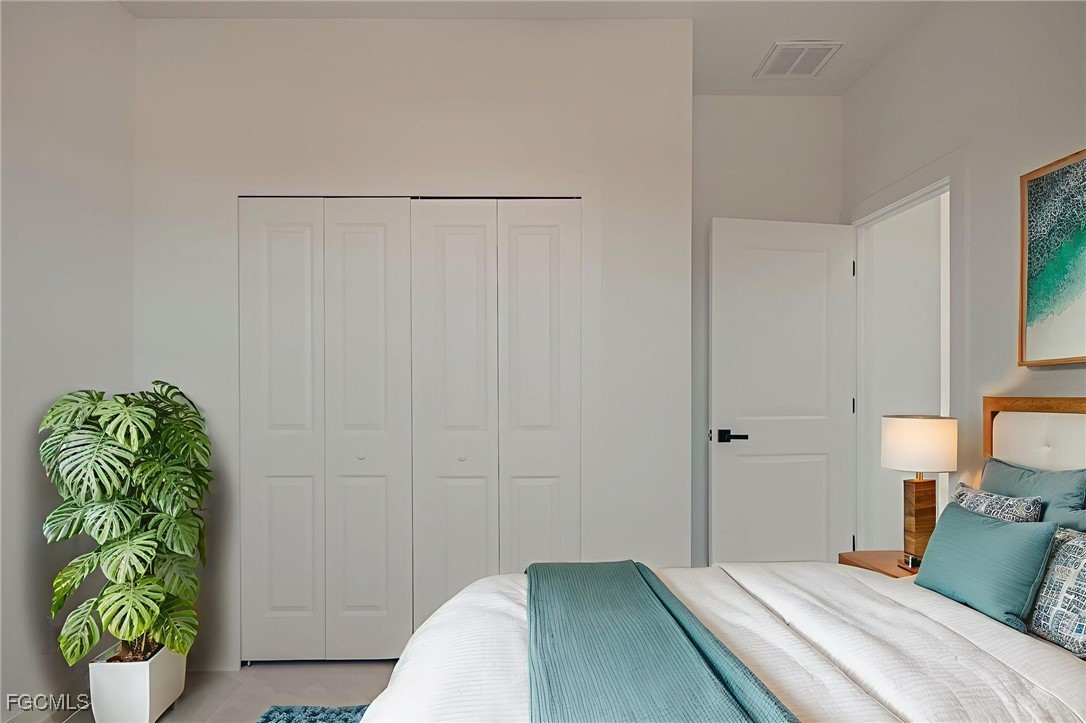 3601 28th Street Southwest Lehigh Acres, FL 33976 - Photo 4 of 35 a bedroom with a bed and a potted plant