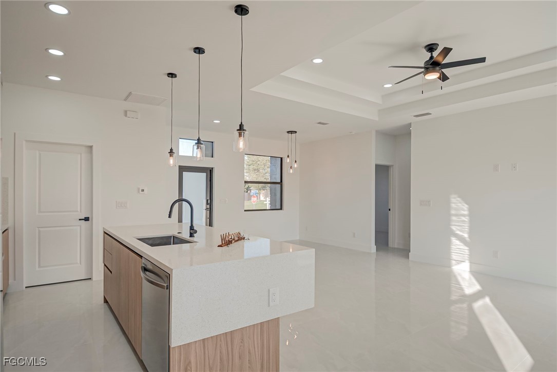 3601 28th Street Southwest Lehigh Acres, FL 33976 - Photo 7 of 35 a kitchen with stainless steel appliances a sink a refrigerator a center island a stove and a window