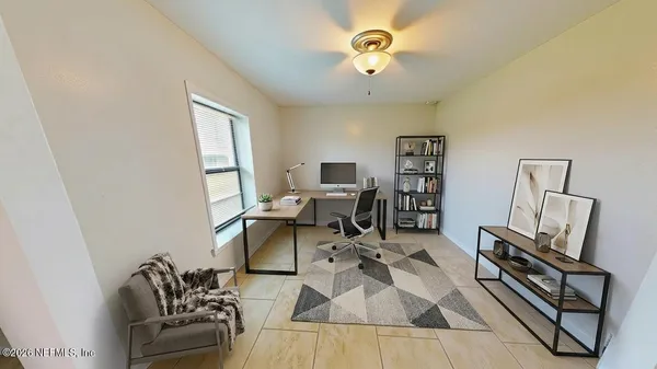 a view of a workspace with furniture and a window