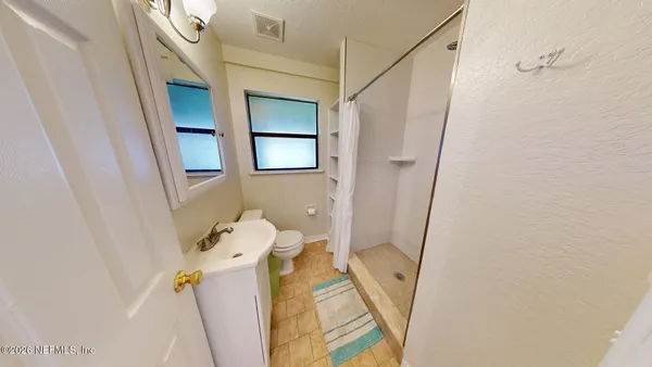 a bathroom with a sink and mirror with toilet