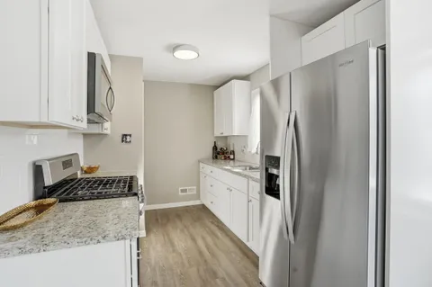 a kitchen with stainless steel appliances granite countertop a refrigerator and a stove