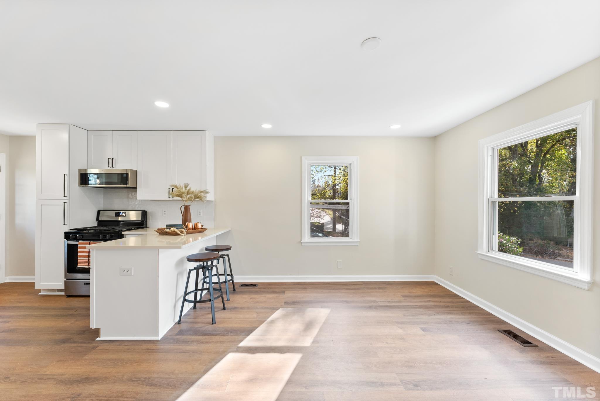 401 Plainview Avenue Raleigh, NC 27604 - Photo 7 of 28 a kitchen with kitchen island granite countertop a stove top oven a sink a counter space and cabinets