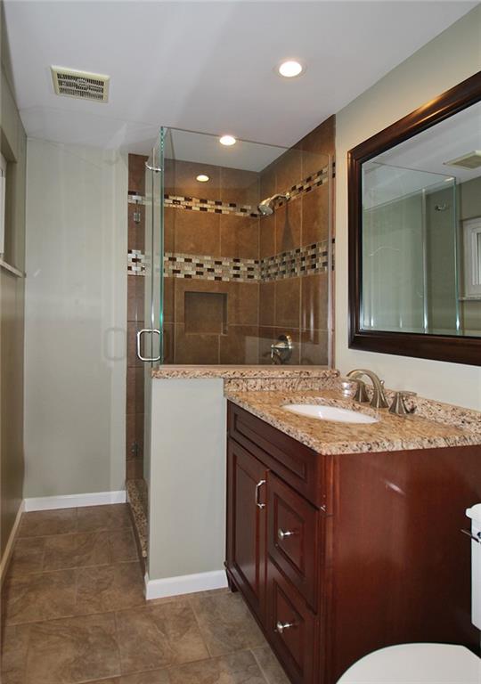 Undisclosed Address Cecil, PA 15321 - Photo 12 of 29 a bathroom with a granite countertop sink a mirror and a toilet