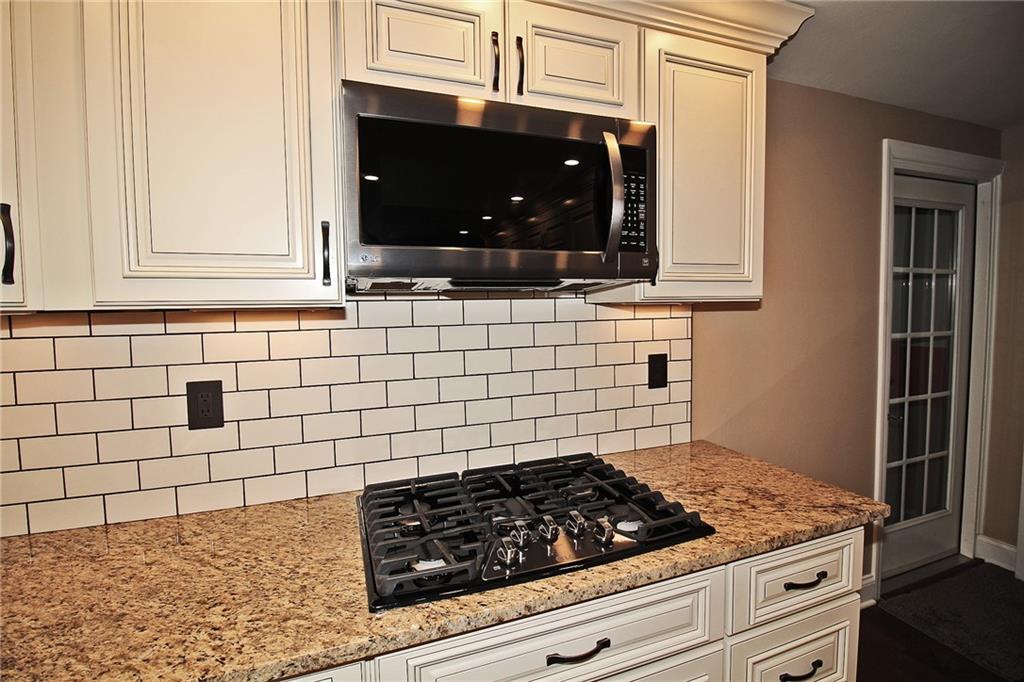 Undisclosed Address Cecil, PA 15321 - Photo 6 of 29 a kitchen with granite countertop white cabinets and stainless steel appliances