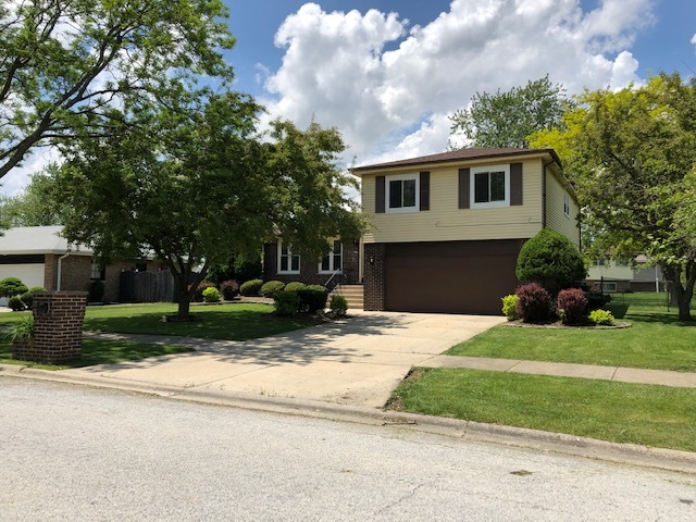 624 Quail Run Road Matteson, IL 60443 - Photo 1 of 30 a front view of a house with a garden and trees