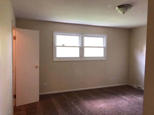 624 Quail Run Road Matteson, IL 60443 - Photo 25 of 30 an empty room with wooden floor and windows