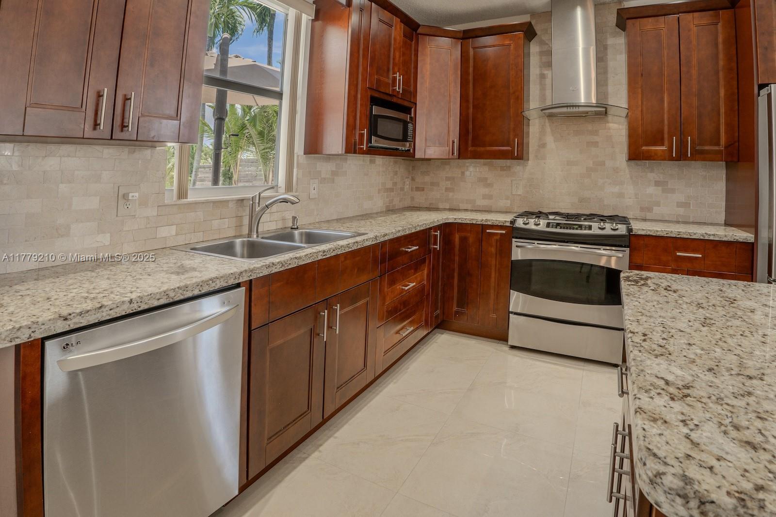 Towngate Pembroke Pines, FL 33028 - Photo 12 of 41 a kitchen with stainless steel appliances granite countertop a sink stove and microwave