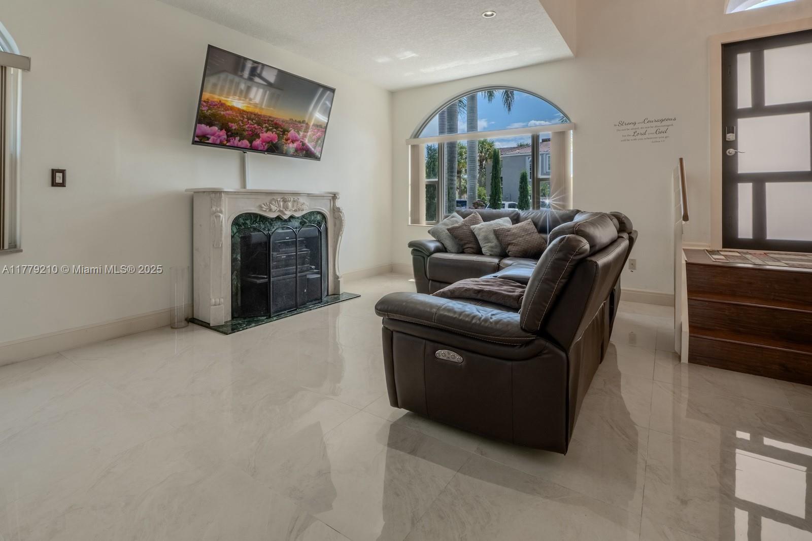 Towngate Pembroke Pines, FL 33028 - Photo 13 of 41 a living room with furniture a fireplace and a flat screen tv