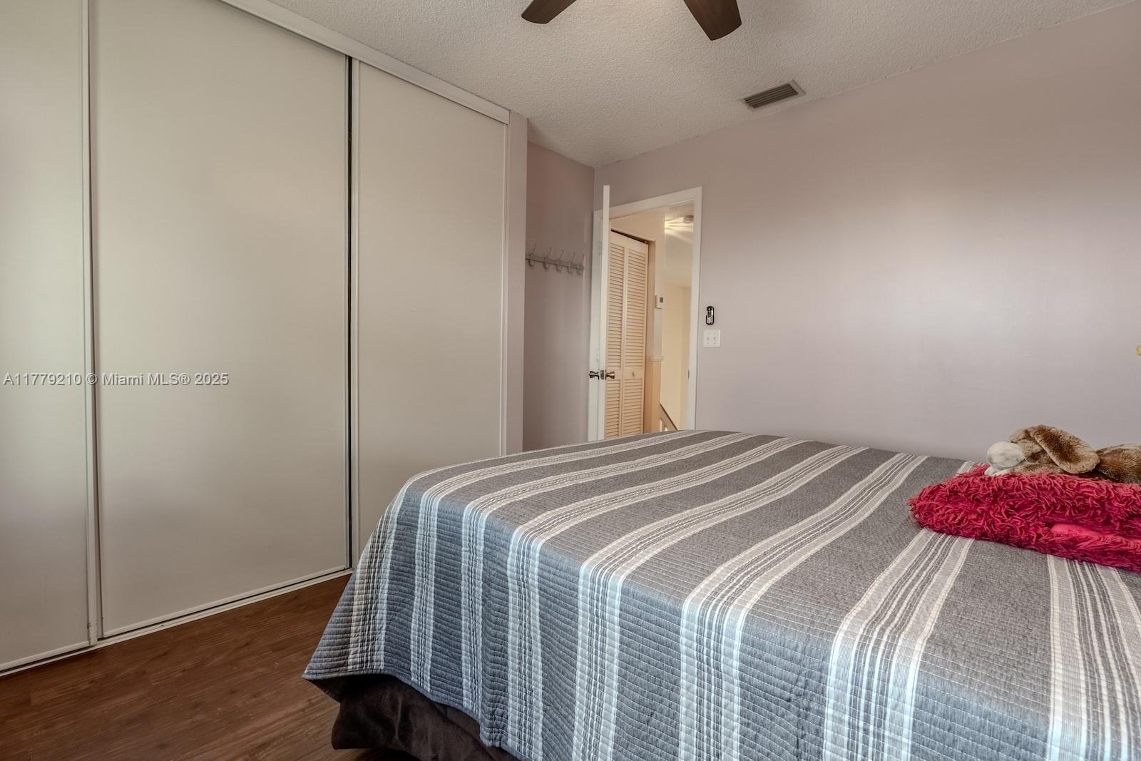 Towngate Pembroke Pines, FL 33028 - Photo 22 of 41 a bedroom with a bed and wooden floor