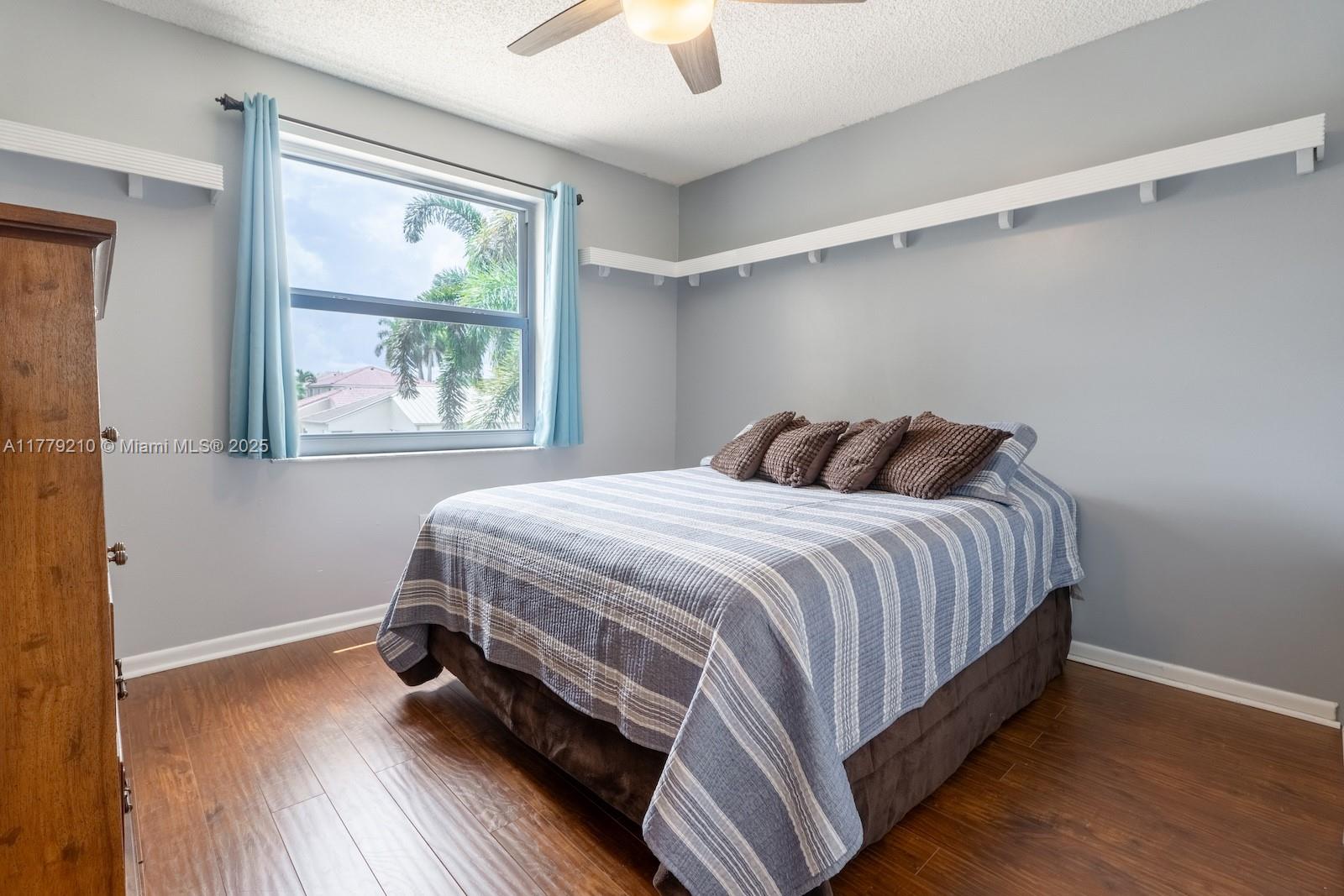 Towngate Pembroke Pines, FL 33028 - Photo 24 of 41 a bedroom with a bed and a window with wooden floor
