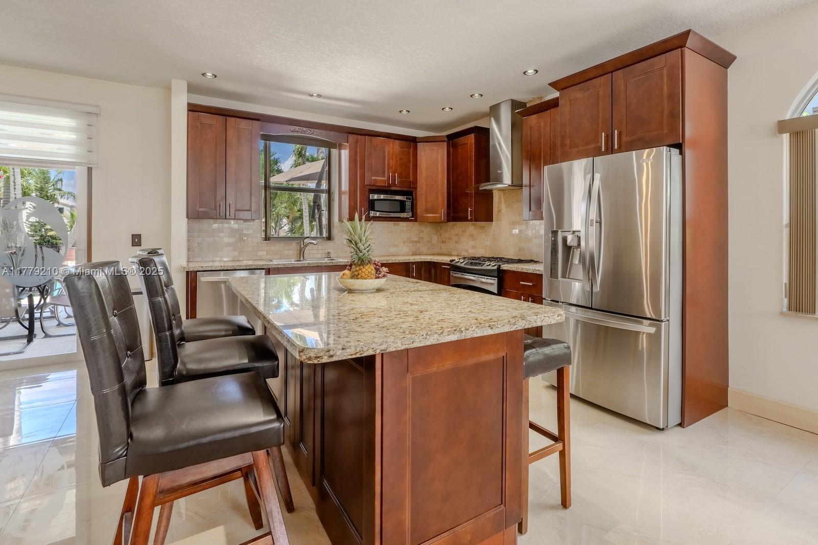 Towngate Pembroke Pines, FL 33028 - Photo 6 of 41 a kitchen with stainless steel appliances granite countertop a refrigerator a stove a kitchen island a table and chairs