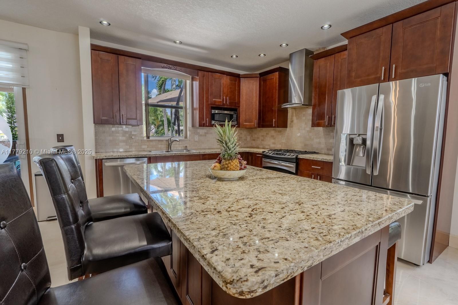 Towngate Pembroke Pines, FL 33028 - Photo 7 of 41 a kitchen with granite countertop a refrigerator a stove and white cabinets