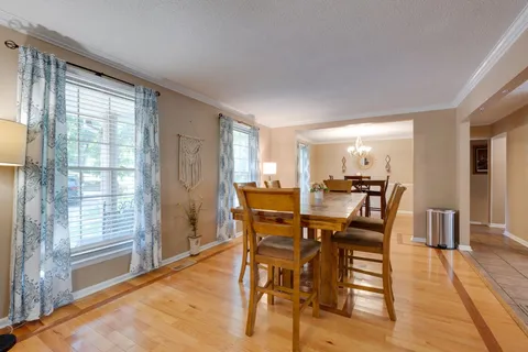 a kitchen with stainless steel appliances granite countertop a refrigerator a sink dishwasher a stove and white cabinets with wooden floor