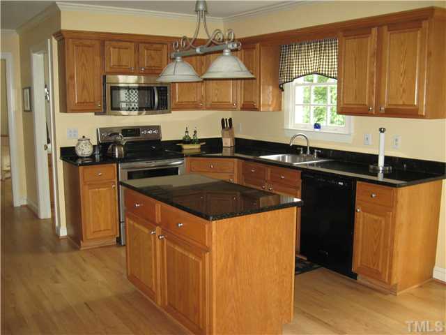 14405 Possum Track Road Raleigh, NC 27614 - Photo 4 of 25 Beautifully updated kitchen with granite countertops, stainless stove and microwave and new cabinets.