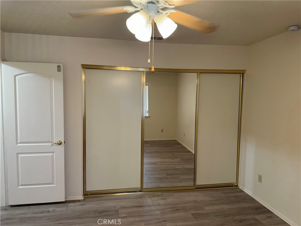 14572 Lighthouse Lane Helendale, CA 92342 - Photo 14 of 24 a view of a room with wooden floor a chandelier fan and closet area