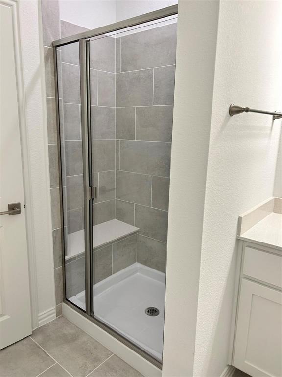 4704 Craymore Road Dallas, TX 75228 - Photo 10 of 14 a bathroom with a glass shower door