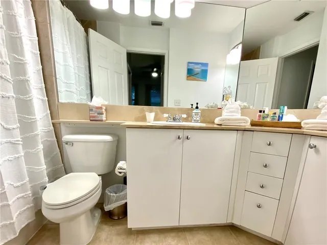 a bathroom with a sink a toilet a mirror a vanity and shower