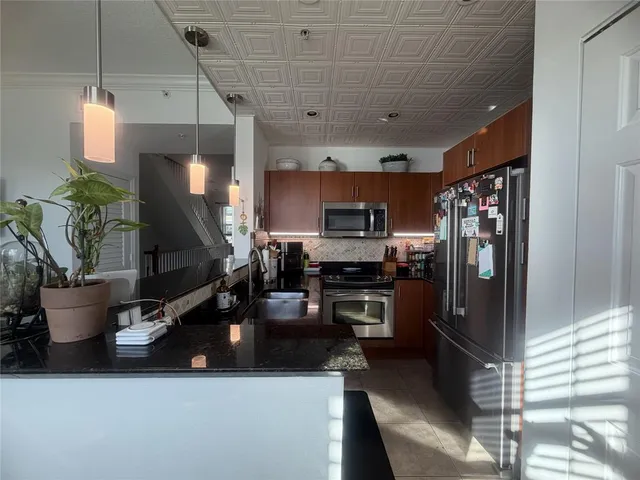 a kitchen with stainless steel appliances a refrigerator a sink a stove and a refrigerator