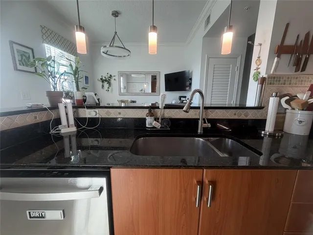 a kitchen with stainless steel appliances granite countertop a sink a stove counter space and cabinets