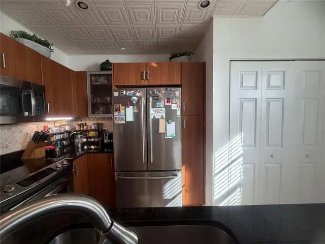 a kitchen with a refrigerator and a stove top oven