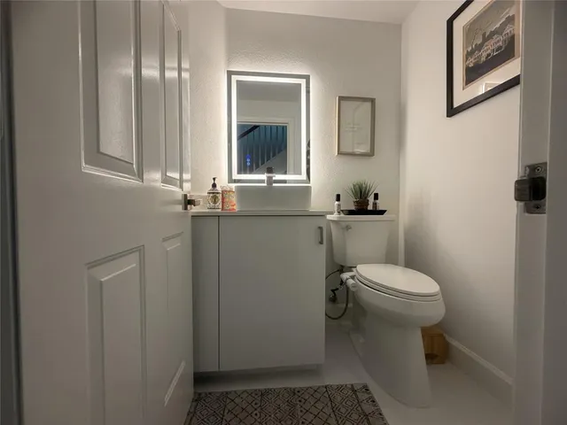 a bathroom with a sink a toilet and mirror