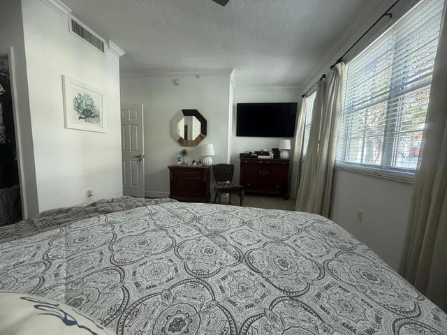 a bedroom with a bed dresser and a window