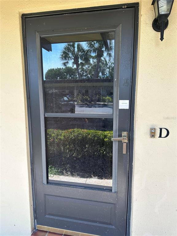 1701 Pinehurst Road, Unit 8D Dunedin, FL 34698 - Photo 1 of 1 a view of a glass door with a tree