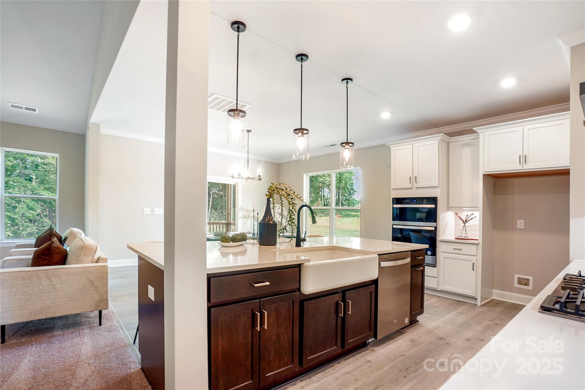 522 Fern Hill Road, Unit 17 Mooresville, NC 28117 - Photo 4 of 16 a open kitchen with stainless steel appliances granite countertop a sink dishwasher a refrigerator and a dining table with wooden floor