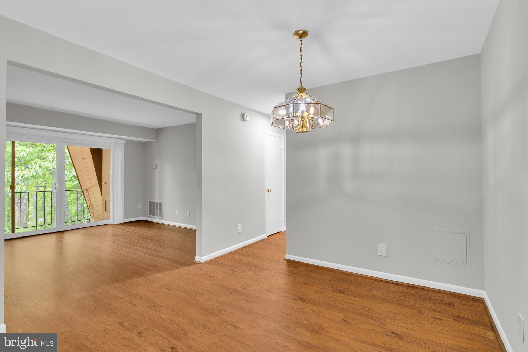 11620 Vantage Hill Road, Unit 22B Reston, VA 20190 - Photo 5 of 24 a view of an empty room with chandelier and wooden floor