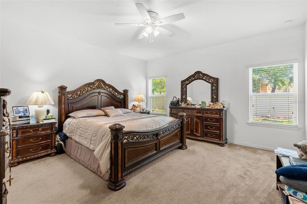 2085 Lula Road Minneola, FL 34715 - Photo 28 of 39 a bedroom with a bed next to a window with a chandelier