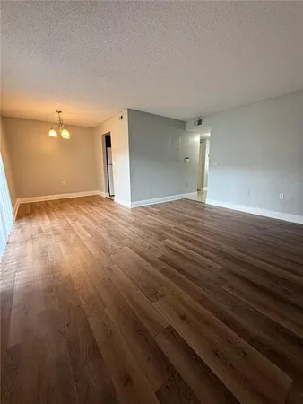 a view of an empty room and wooden floor