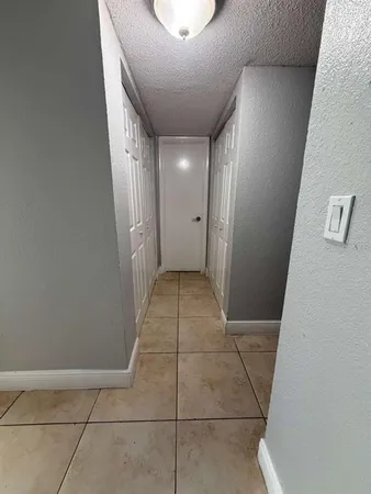 a view of an empty room with wooden floor and window