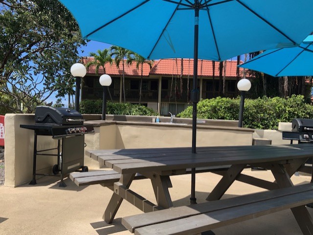 75-5873 Walua Road, Unit 118 Kailua-Kona, HI 96740 - Photo 11 of 11 a view of a chairs and table under an umbrella in patio