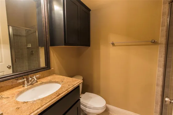 a bathroom with a granite countertop sink toilet and shower