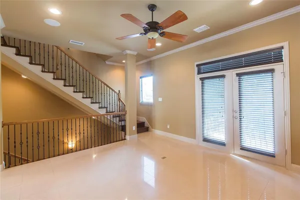a view of an empty room with a chandelier fan