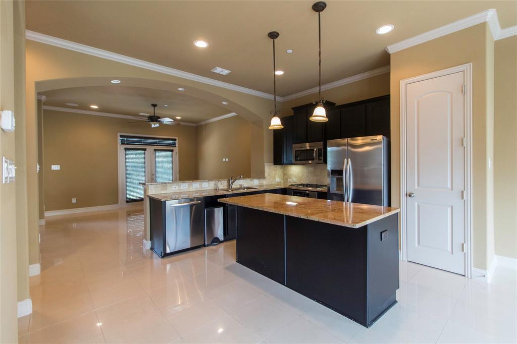 7416 Bishop Road Plano, TX 75024 - Photo 21 of 40 a large kitchen with a large counter top a sink and stainless steel appliances