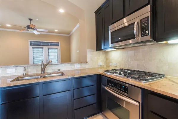 a kitchen with stainless steel appliances a stove sink and microwave
