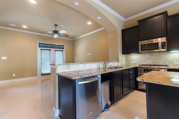 a kitchen with stainless steel appliances granite countertop a sink and a microwave