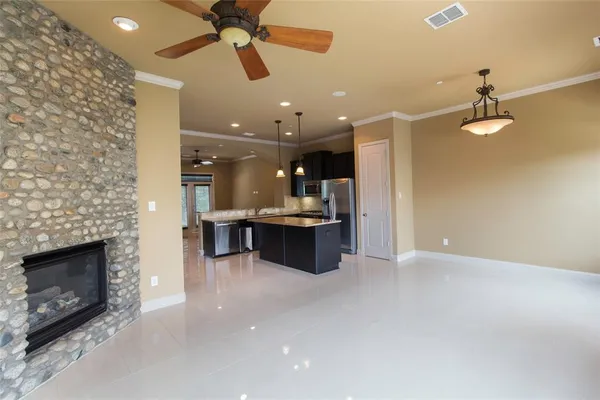 a living room with stainless steel appliances kitchen island furniture and a fireplace