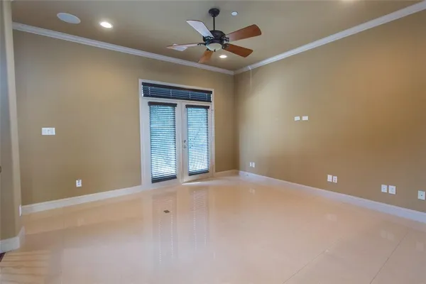 a view of an empty room with a ceiling fan and window