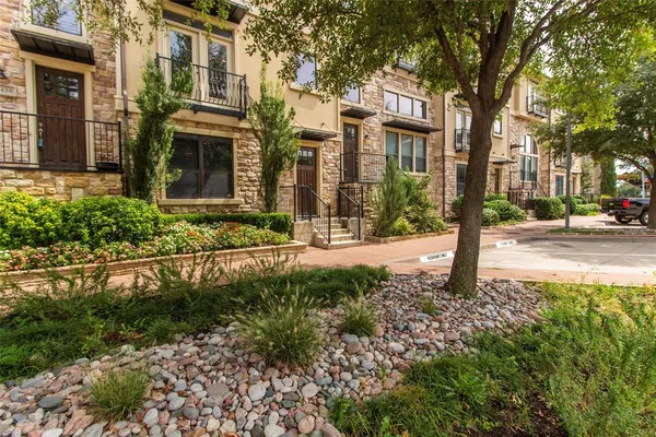 a view of a building with a yard and plants