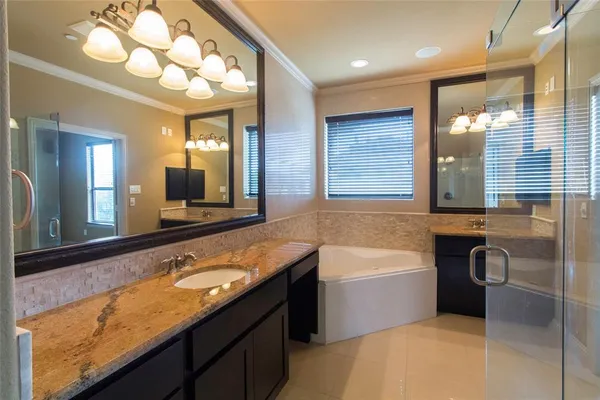 a bathroom with a granite countertop sink and a bathtub