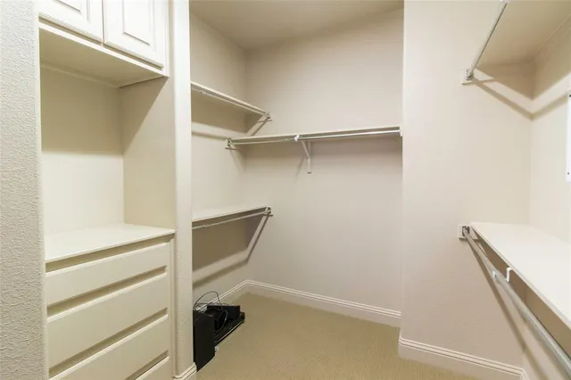 a view of walk in closet with empty racks
