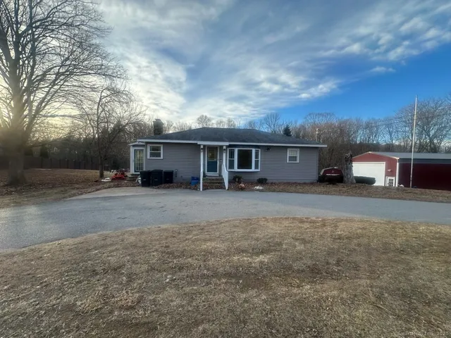 a front view of a house with a yard and trees