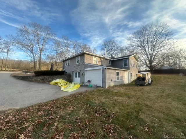 a view of a house with a patio and a yard