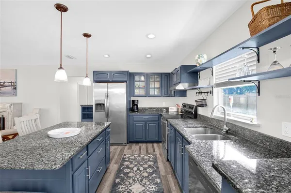 a kitchen with granite countertop stainless steel appliances and wooden cabinets