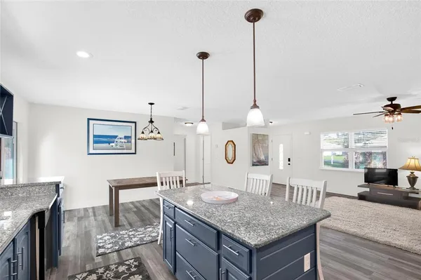 a dining hall with stainless steel appliances granite countertop a stove and a wooden floors